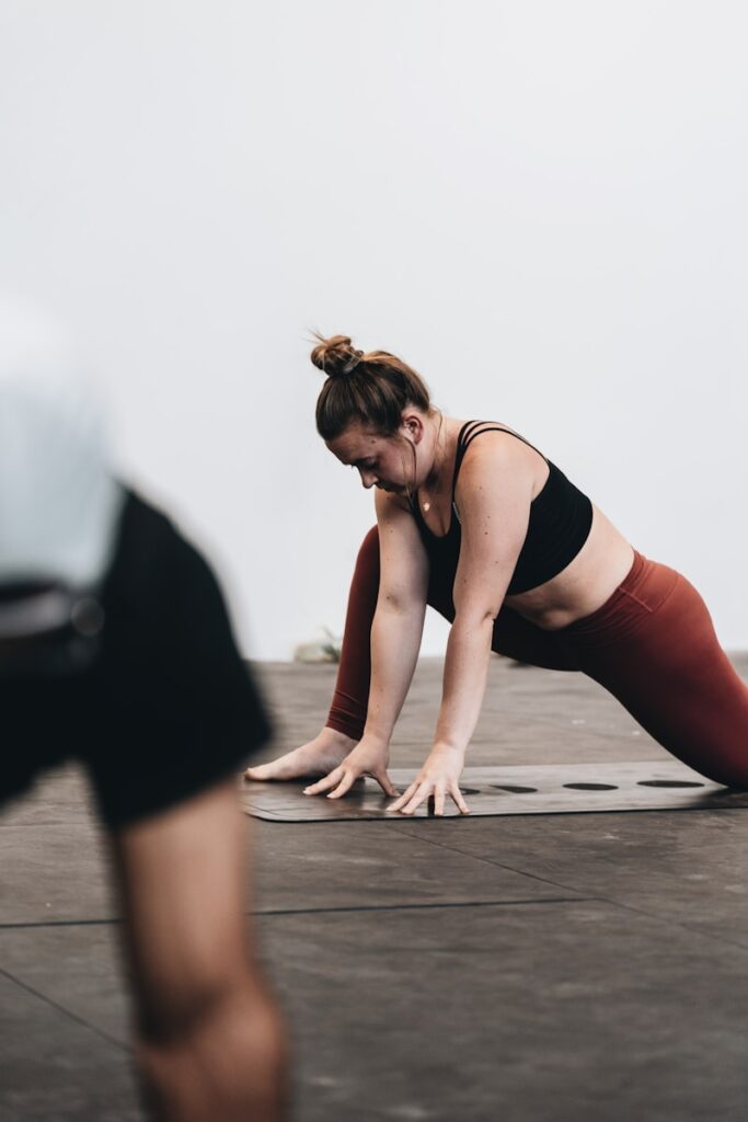 Photo by LOGAN WEAVER | @LGNWVR woman in black tank top and white pants doing yoga